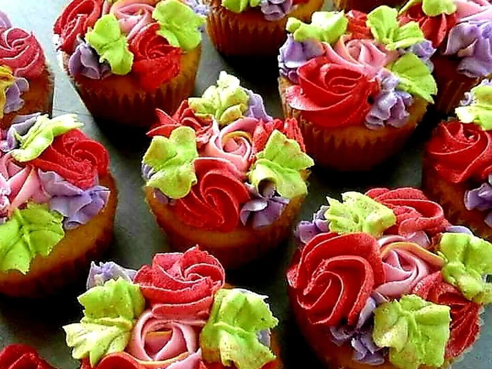 Red cupcakes decorated with colourful piped floral icing at Mr Bake.