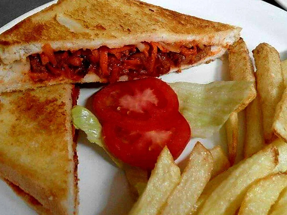 A toasted Mr Bake sandwich served with chips and salad.