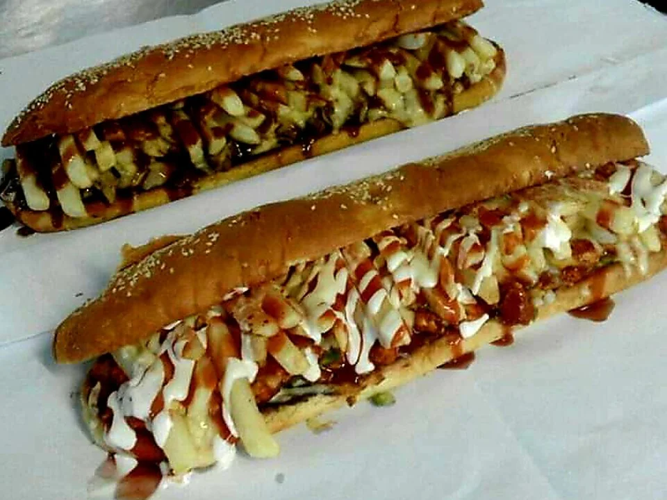Two filled Mr Bake Gatsby rolls topped with sauce.